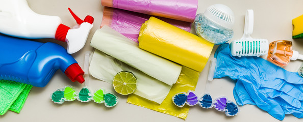 banner of various detergents and the necessary attributes for cleaning, washing and ironing in the background. copy space