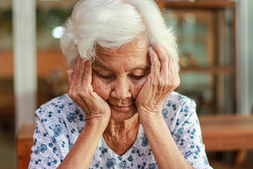 Asian woman with white hair shows signs of memory impairment. Health problems and treatment costs.