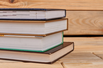 Four books on wooden background. Stack of books. Education and information concept.