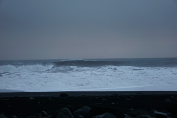 Black Rocks With Smashing Waves In The Background At Reynisfjara Beach In Iceland