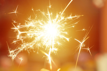 Sparks from hand cold fireworks bright sunspot background