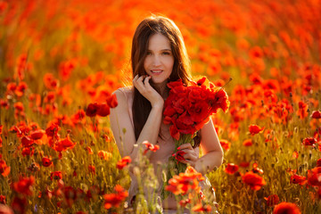 young girl in a field with red poppies