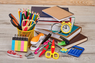 Stationery supplies on wooden background. Workspace with assorted school or office items. Back to school concept.