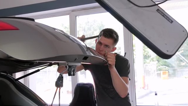 Paintless Dent Repair Removal. Tap Down Tools Dent Rubber Hammer Auto Body. The guy knocks with a hammer on the car to align the dent on technology PDR.