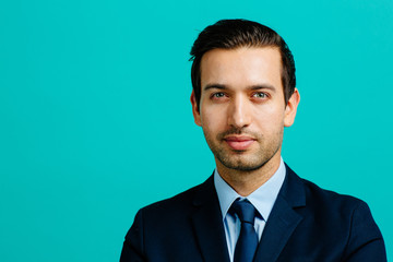 Portrait of a young man in suit and tie, isolated on blue