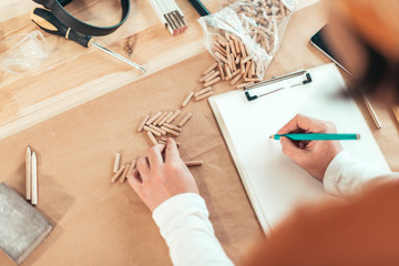 Female carpenter working with wooden dowels