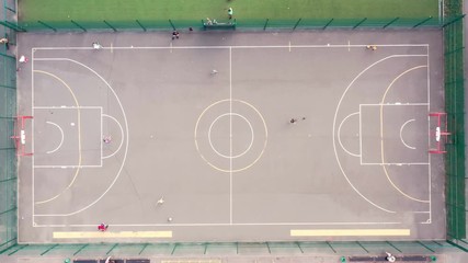 Kids and adults playing at the city playground with football and basketball fields markings. This 3840x2160 (4K) video depicts sport and recreation, happy young new generation. - Powered by Adobe