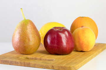 Fototapeta na wymiar red apple, pear, lemon, orange, peach on white background, copy space
