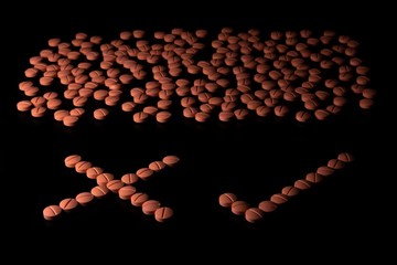 Orange colour round pills on black background with selective focus. Pills that look like ecstasy.