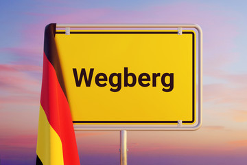 Wegberg. Gelbes Schild/Ortsschild. Flagge von Deutschland hängt darüber. Himmel mit Sonnenuntergang oder Sonnenaufgang