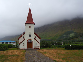 Fototapeta na wymiar Church at Flateyri in the Westfjords of Iceland standing out against low cloud in the background