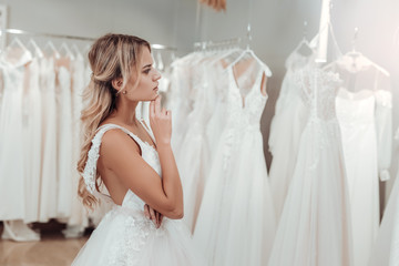 Naklejka premium Thoughtful young woman choosing her wedding dress.