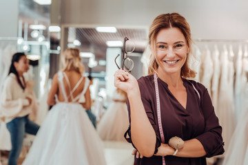 Wedding dress designer standing in her shop.