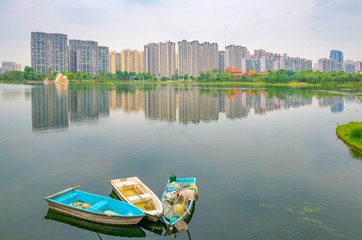 Fototapeta na wymiar Buildings and garbage boats in Jincheng Lake, Chengdu, Sichuan Province, China