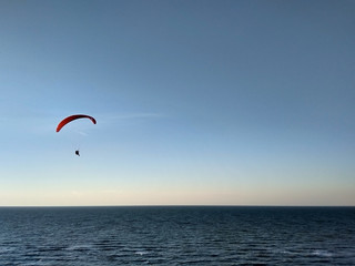 Paraglider flies over the sea before sunset.Expanse. Air sports.