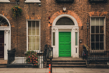 Old house with green front door and red brick wall in Dublin, Ireland
