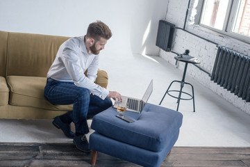 Bearded hipster boy professional freelance social media content writer keyboarding on laptop...