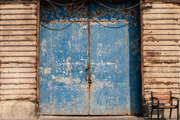 Locked shabby door of the old warehouse in the port of Jaffa, Tel Aviv, Israel. Closeup of blue faded gate in sea harbour.