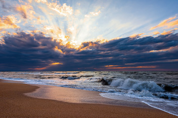 Beach with waves at colorful sunset