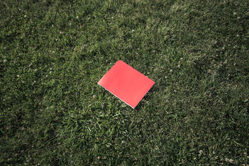 red book on green grass