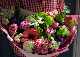 a bright bouquet of fresh flowers in the hands of a young girl
