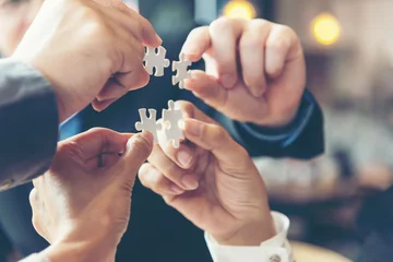 Fotobehang Businessman team work holding two jigsaw connecting couple puzzle piece for matching to goals target, success and start up new project in office, select focus. Business Concept. © freebird7977