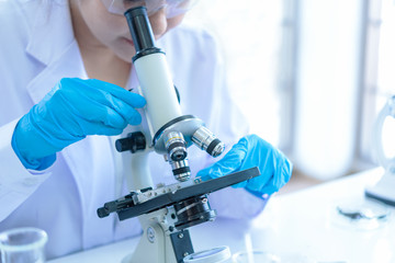 Scientists analyzing study data and evaluating microscope. Health care researchers doing some...