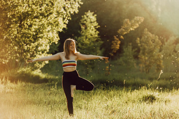 Beautiful girl doing yoga in nature on a sunny summer day.