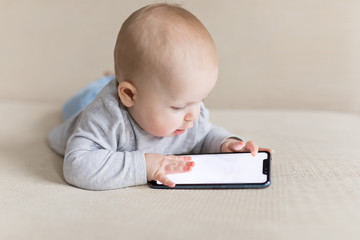 Little baby child is playing with smartphone learning how to communicate with new technologies - 277532077