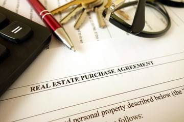 Real estate purchase agreement for filling with pen calculator keys and glasses