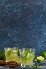 Summer cold drink - mahito with lime and mint on a concrete dark background.