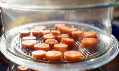 Chopped carrots cooking in a steamer.