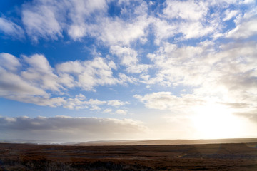 Fototapeta premium Blue sky and sun rising over Blanchland Common moors in the North of England.
