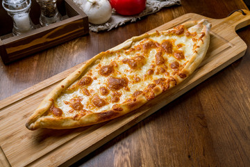 Turkish pide with cheese on wooden background