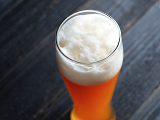 Close-up of a glass of wheat beer on a dark wooden background