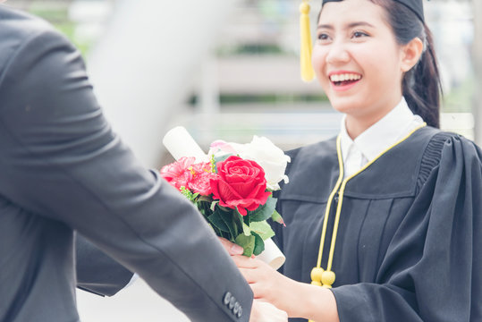 Graduated woman concept. Young smiling woman got flower after finish education. Graduate people finish academy university.