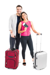 Smiling Couple Standing With Luggage In Studio