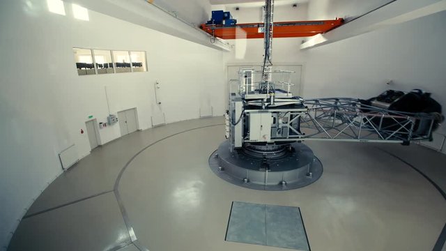 A capsule spinning around in a small empty round room. At the beggining it's spinng fast, then it's slowing down.