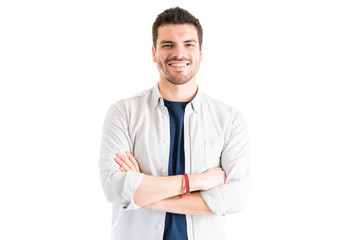 Confident Man Standing With Arms Crossed Against White Background