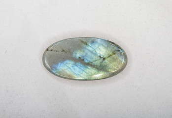 Natural oval labradorite gem on the white background