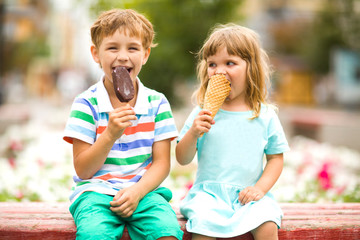 Cute happy kids eating icecream outdoors. childhood concept.