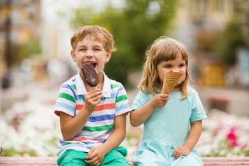 Fototapeta na wymiar Cute happy kids eating icecream outdoors. childhood concept.