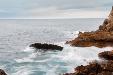 Fototapeta na wymiar waves crashing against the rocks of the beach of the hermitage of santa justa in cantabria
