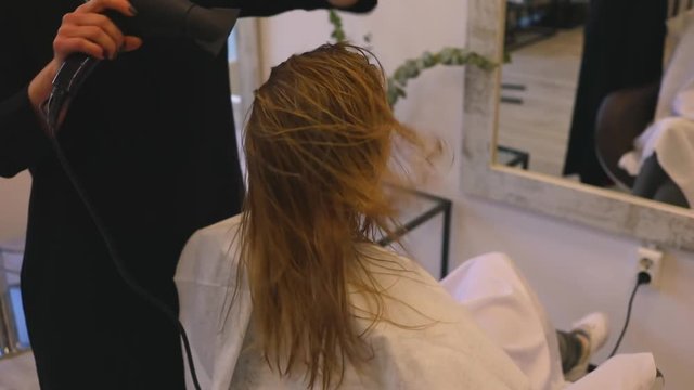 blondie girl in beauty salon professional drying technique dryer aims hair ends