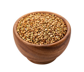 Brown wooden bowl with uncooked green buckwheat grain