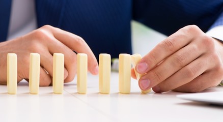 Young businessman playing with domino in office