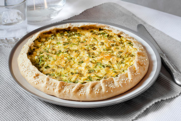 Tart with eggs and green onions on a plate