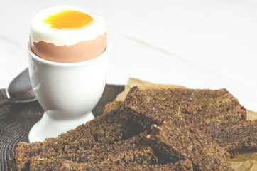 Healthy food. English breakfast with boiled egg and croutons on a white wood background
