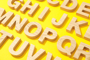 Wooden letters of English alphabet on color background
