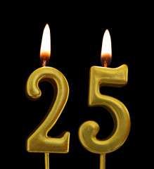 Burning golden birthday candles on black background, number 25